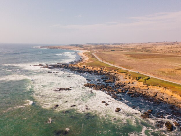 Luftaufnahme des welligen Ozeans, der die felsigen Klippen am Pazifischen Ozean in Kalifornien trifft