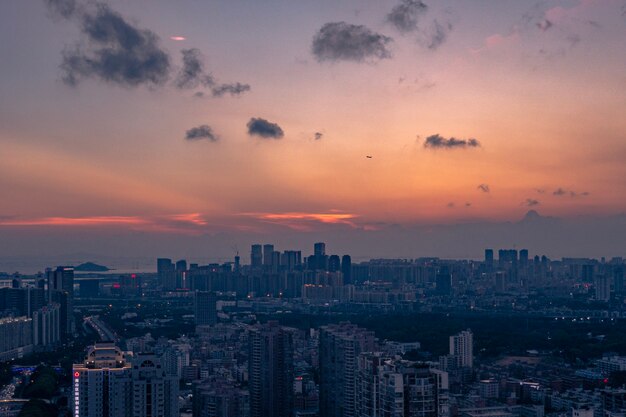 Luftaufnahme einer großen Stadt unter einem orange-blauen bewölkten Himmel bei Sonnenuntergang