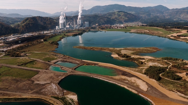 Luftaufnahme einer Landschaft umgeben von Bergen und Seen mit industrieller Katastrophe