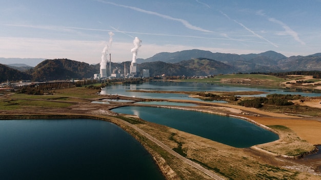 Luftaufnahme einer Landschaft umgeben von Bergen und Seen mit industrieller Katastrophe