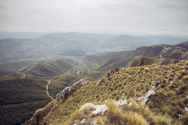 Kostenloses Foto luftaufnahme einer landstraße, die durch die bäume und berge führt