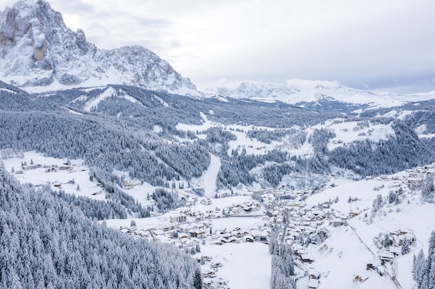 Luftaufnahme einer Stadt im Winter, umgeben von Bergen