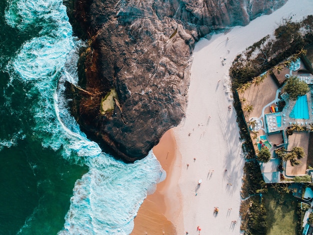 Luftaufnahme eines Strandes in Rio de Janeiro mit Häusern auf dem Berg