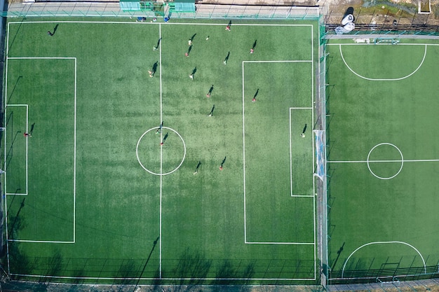 Luftaufnahme von fußballspielern, die fußball auf dem grünen sportstadion spielen.