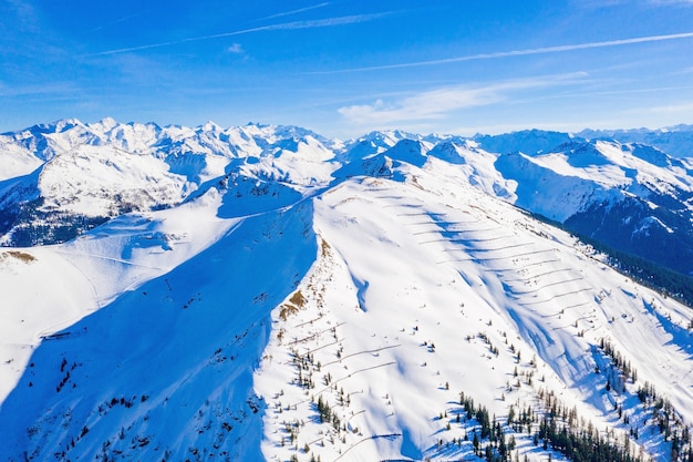 Luftaufnahme von hohen schneebedeckten Bergen in Österreich an einem sonnigen Tag
