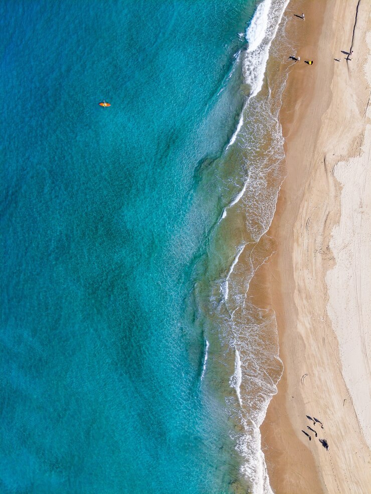 Kostenlose Foto luftaufnahme von leuten, die den strand an einem sonnigen tag genießen