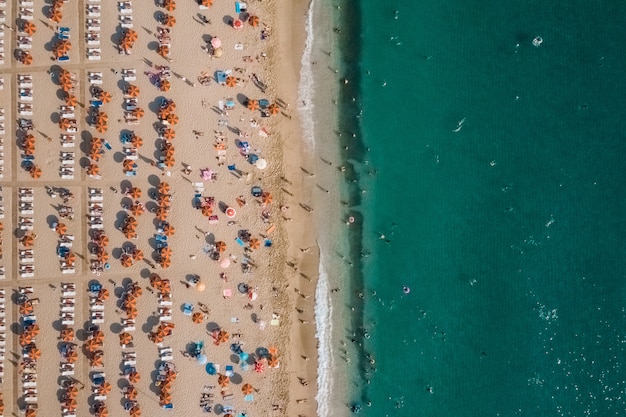 Luftaufnahme von Menschen, die auf dem Strand nahe dem Meer ruhen