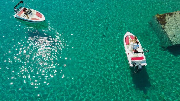 Luftaufnahme von Menschen, die Motorboote auf einem transparenten Meer fahren