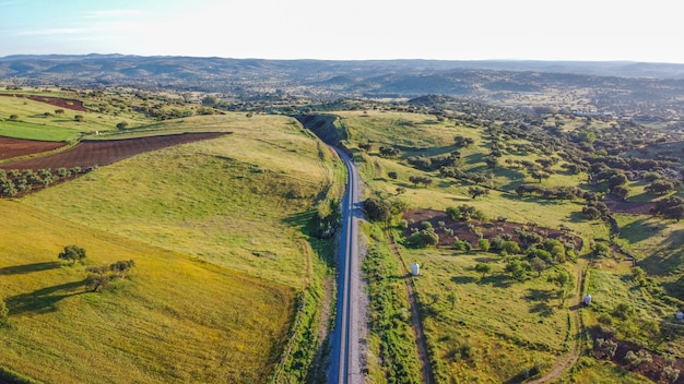 Luftaufnahme von weitläufigem Ackerland mit einer Landstraße in der Mitte