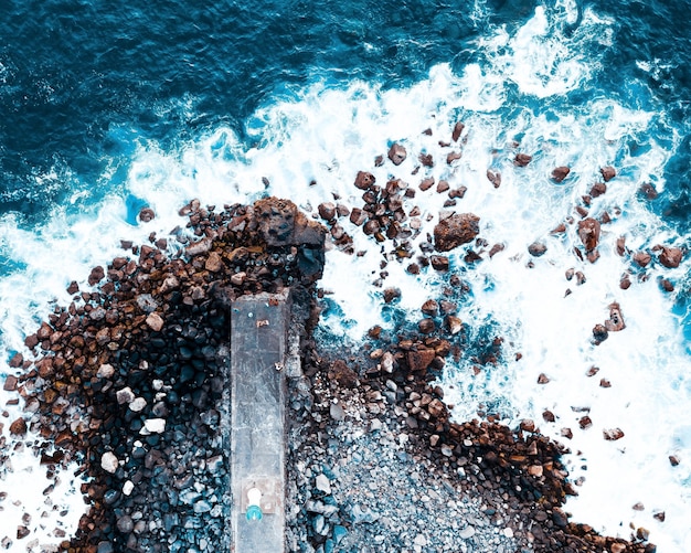 Luftaufnahme von Wellen, die auf Felsen krachen