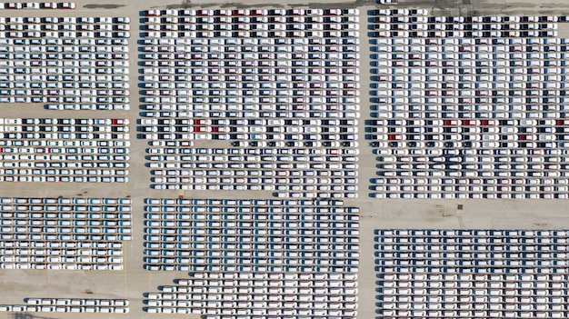 Luftbild viele fahrzeuge auf dem parkplatz für neuwagen für den export, business und logistik