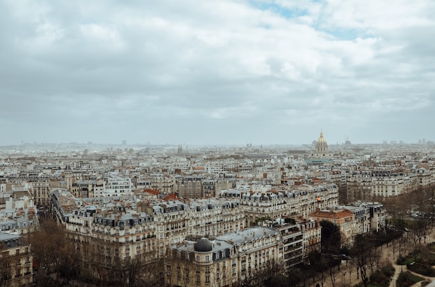 Luftbild von Paris bedeckt im Grünen und in den Gebäuden unter einem bewölkten Himmel in Frankreich