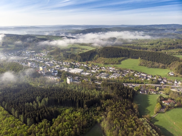 Luftbildaufnahme von schönen grünen Feldern und Häusern der Landschaft an einem sonnigen Tag