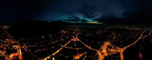 Luftdrohne Weitblick auf Brasov bei Nacht Rumänien Altstadt Nachtlichter Gebäude Straßen