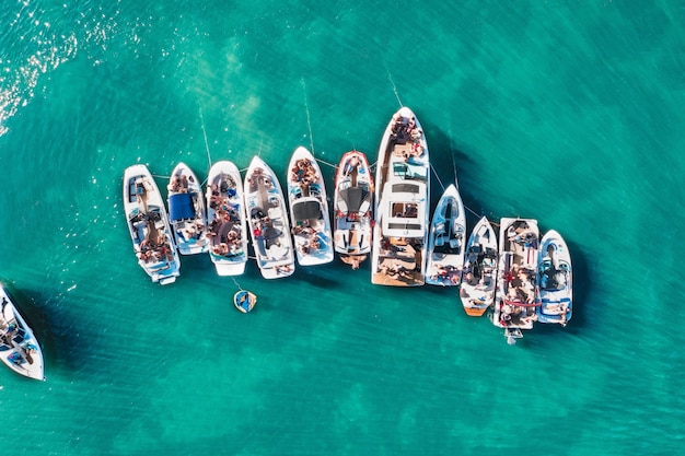 Kostenloses Foto luftdrohnenaufnahme von booten unterschiedlicher größe, die nahe beieinander in der nähe des piers angedockt sind