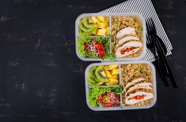 Lunchbox Huhn, Bulgur, Microgreens, Tomaten und Obst. Gesundes Fitness-Essen. Wegbringen. Brotdose. Draufsicht