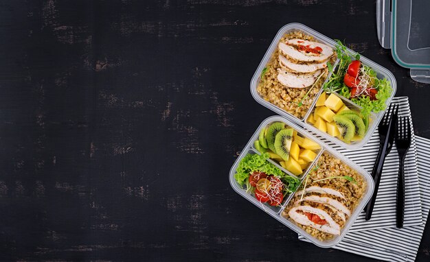 Lunchbox Huhn, Bulgur, Microgreens, Tomaten und Obst. Gesundes Fitness-Essen. Wegbringen. Brotdose. Draufsicht