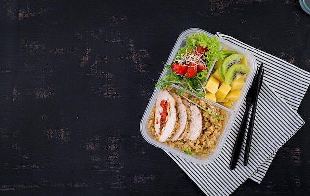 Lunchbox Huhn, Bulgur, Microgreens, Tomaten und Obst. Gesundes Fitness-Essen. Wegbringen. Brotdose. Draufsicht