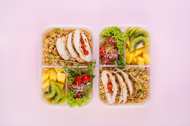 Lunchbox Huhn, Bulgur, Microgreens, Tomaten und Obst. Gesundes Fitness-Essen. Wegbringen. Brotdose. Draufsicht