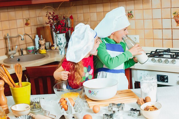 Lustige Familie lustige Kinder bereiten den Teig vor, backen Kekse in der Küche