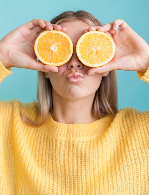 Lustige Frau, die Orangen hält