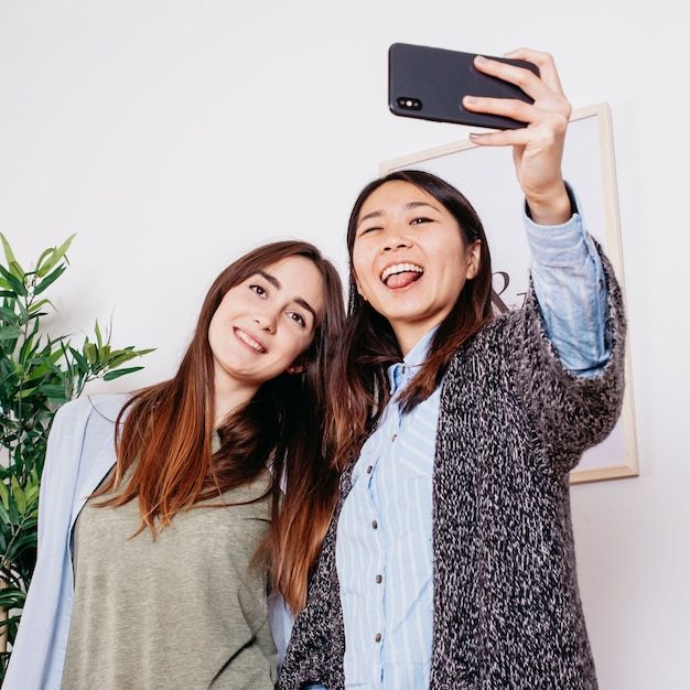 Kostenloses Foto lustige frauen, die für selfie aufwerfen