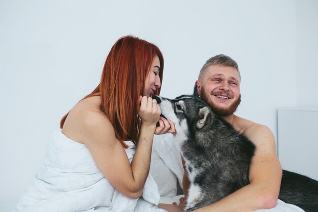 Lustige Paare mit ihrem Haustier spielen