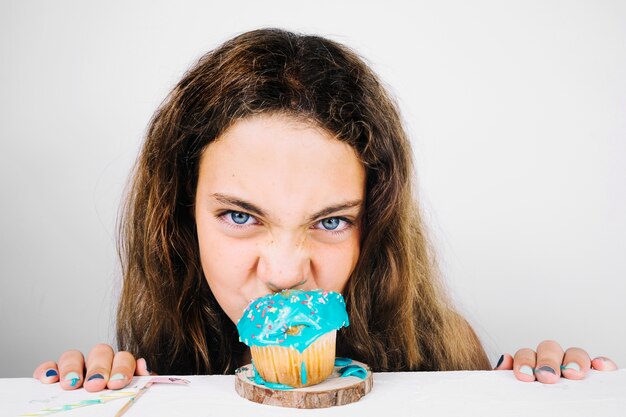 Lustiger jugendlicher beißender kleiner Kuchen