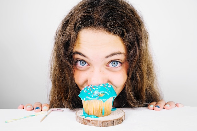 Lustiger Jugendlicher, der kleinen Kuchen isst