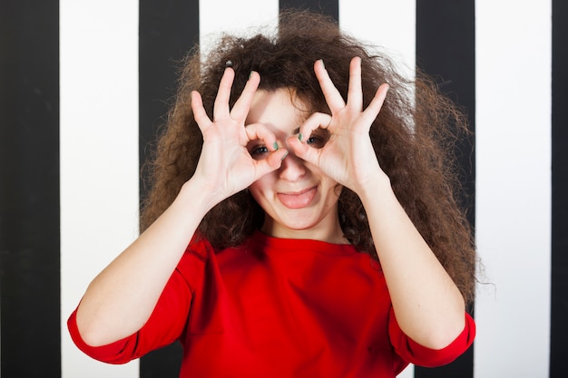 Lustiges Brunettemädchenporträt auf gestreiftem Hintergrund