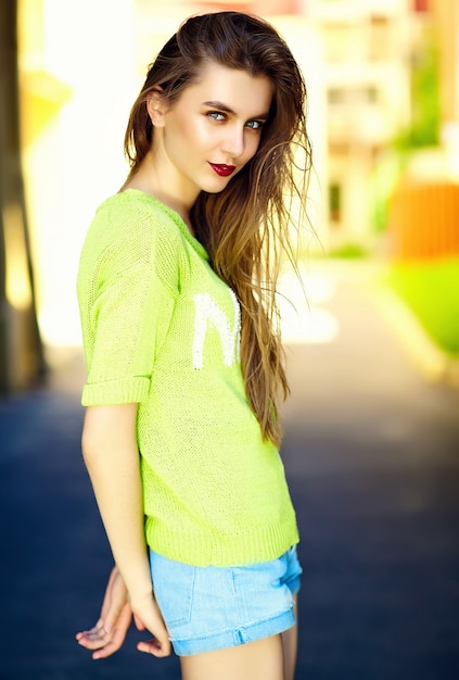 Lustiges stilvolles sexy lächelndes schönes junges Frauenmodell im Sommer hellgelbes Hipster-Tuch in der Straße
