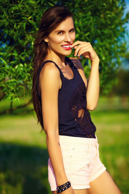 Lustiges stilvolles sexy lächelndes schönes schönes Sonnenbadmodell der jungen Frau im hellen Sommerhüfttuch des Sommers im Park