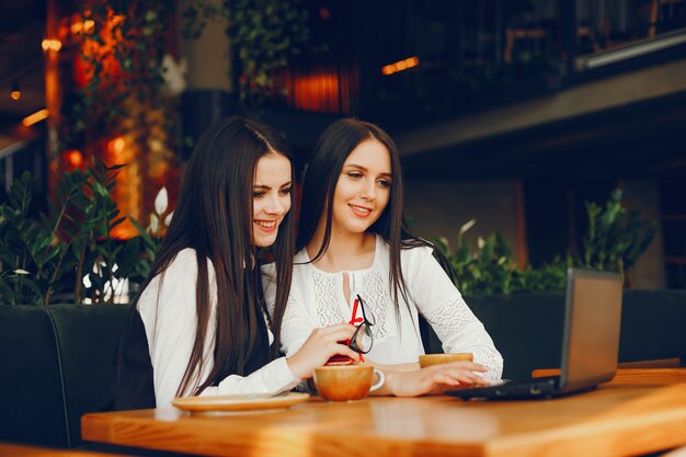 Luxusmädchen zwei, das in einem Restaurant sitzt