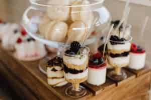 Kostenloses Foto macarons, tiramisu und panna cotta am süßen hochzeitsbuffet