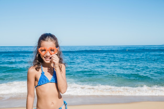 Mädchen am Strand glücklich mit ihrer Schutzbrille