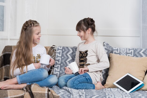 Mädchen auf Couch mit Tassen