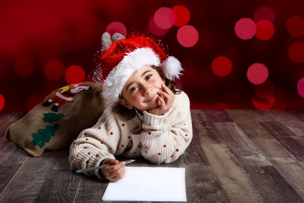 Kostenloses Foto mädchen auf dem boden liegend nachdenklich mit einem bleistift und einem papier