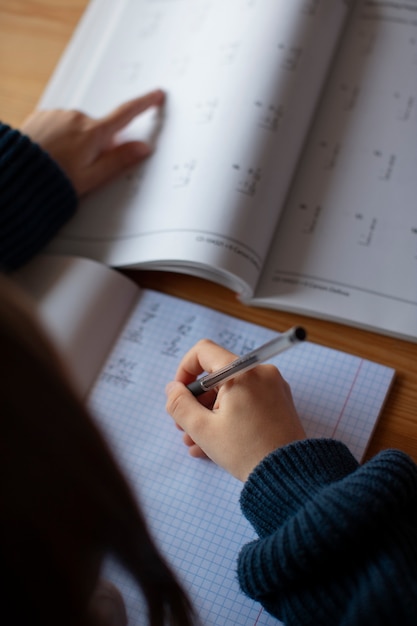 Kostenloses Foto mädchen aus der vogelperspektive lernt in der schule mathematik