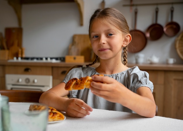 Kostenloses Foto mädchen beim mittagessen in leinenkleidung