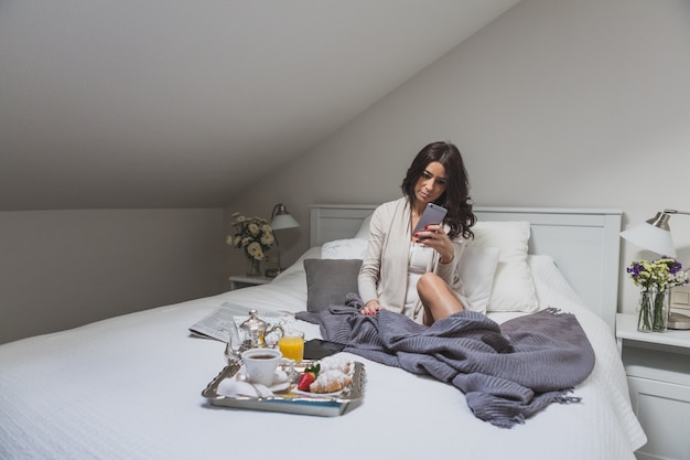 Mädchen Überprüfung ihrer Smartphone im Bett