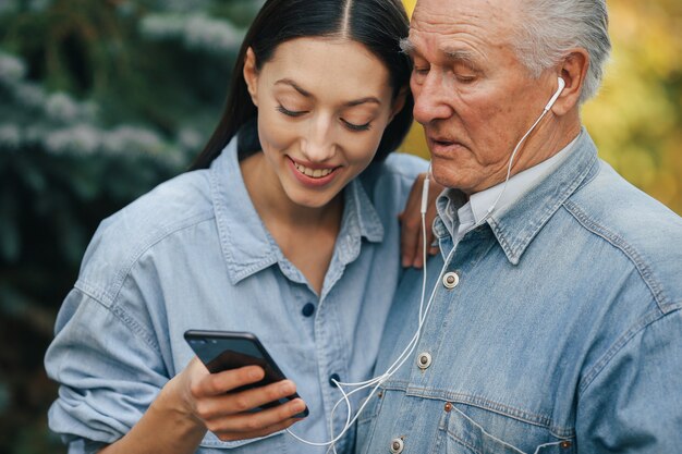 Mädchen bringt ihrem Großvater bei, wie man ein Telefon benutzt