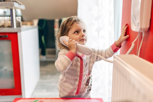 Mädchen, das am Telefon spricht und oben schaut