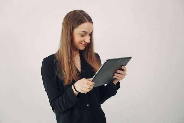 Mädchen, das auf einer weißen Wand mit einem Laptop steht