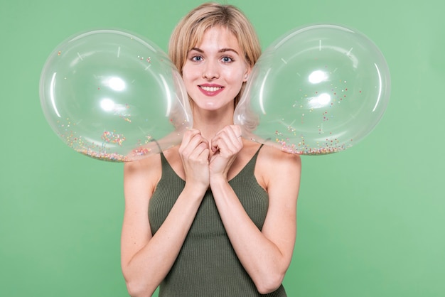 Mädchen, das Ballone nah an ihrem Gesicht hält