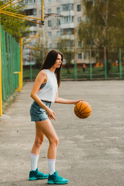 Mädchen, das Basketball in der städtischen Umwelt spielt