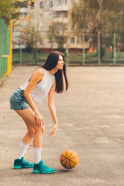 Mädchen, das Basketball in der städtischen Umwelt spielt