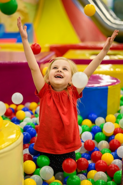 Mädchen, das bunte Ballgrube genießt