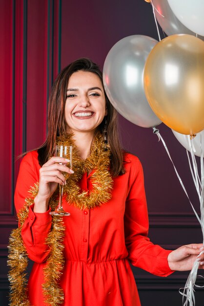 Mädchen, das Champagner mit Ballonen hält