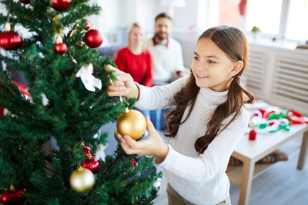 Mädchen, das den Weihnachtsbaum verziert