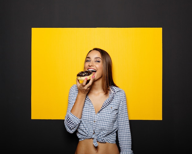 Kostenloses Foto mädchen, das donut mit schokoladenglasur isst